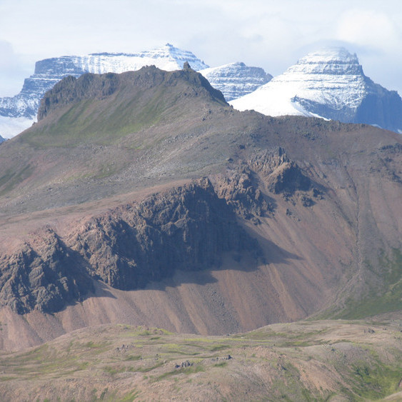 Svartfell í Brúnavík. Dyrfjöll í fjarska