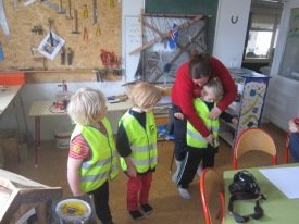 Helga Björg að máta vestin á vorskólabörn