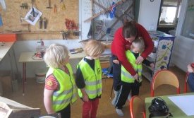 Helga Björg að máta vestin á vorskólabörn